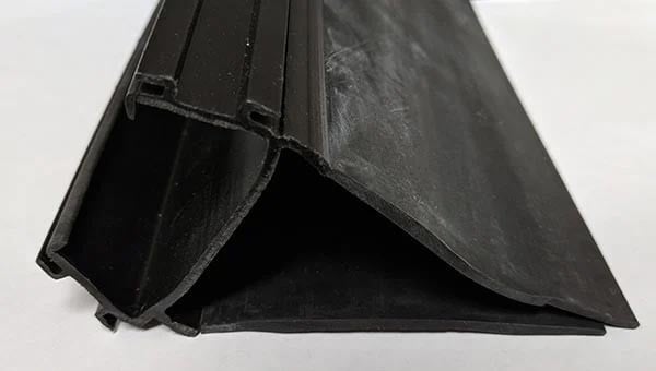 RV slide out coextruded plastic and rubber seal with layer of rubber bloom 